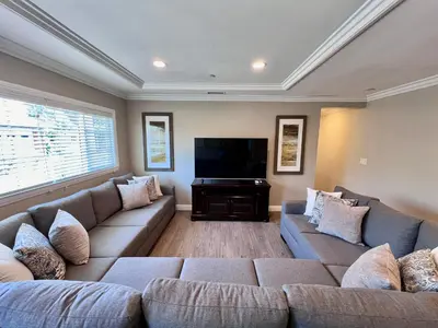 a living room with two couches and a flat screen tv at Stunning 8 bedroom 6 bathroom Pool Home in Anaheim