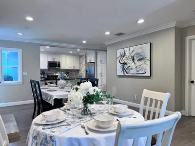 a dining room with a table with white flowers on it at Stunning 8 bedroom 6 bathroom Pool Home in Anaheim