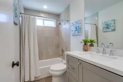 a bathroom with a sink and a toilet and a bath tub at Gorgeous Upgraded 5 Bedroom & 3 Bath Home with pool in Orange
