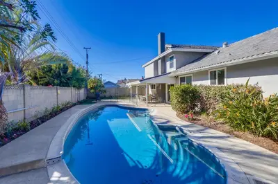 a swimming pool in front of a house at Gorgeous Upgraded 5 Bedroom & 3 Bath Home with pool in Orange