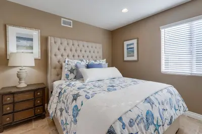 a bedroom with a blue and white bed and a window at Beautiful Backyard Oasis 5 bedroom 3 Bathroom Home in Placentia