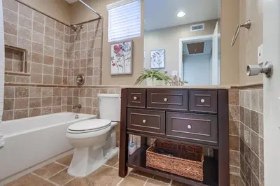 a bathroom with a toilet and a tub and a sink at Beautiful Backyard Oasis 5 bedroom 3 Bathroom Home in Placentia