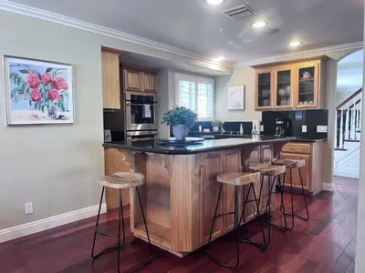 a kitchen with a island with bar stools at Amazing Large Family Home w/Pool, 1 Mile to Disney in Anaheim