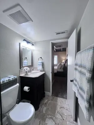 a bathroom with a sink and a toilet and a mirror at Luxurious 2 Bedroom Condo Shortest Walk To Disney in Anaheim