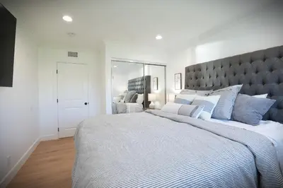 a bedroom with a large bed with a large headboard at Awesome 5 bedroom 3 bath pool home with in-ground jacuzzi in Orange