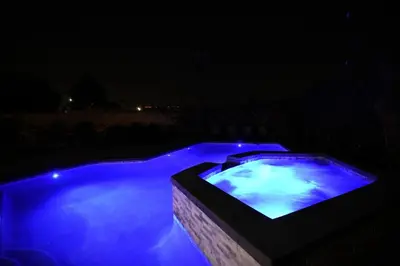 a swimming pool with blue lighting at night at Awesome 5 bedroom 3 bath pool home with in-ground jacuzzi in Orange