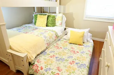 two beds in a small room with yellow pillows at Anaheim California, Beautiful Pool Home, Short Walk to Disney in Anaheim