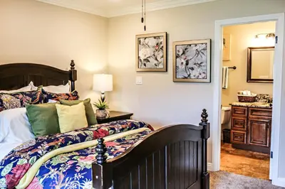a bedroom with a large bed and a bathroom at Wonderful 4 Bedroom 3 Bath Pool Home 3/4 Mile To Disney in Anaheim