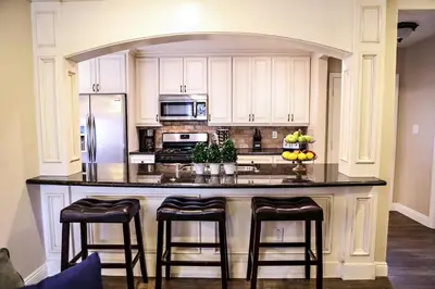 a kitchen with a large island with bar stools at Wonderful 4 Bedroom 3 Bath Pool Home 3/4 Mile To Disney in Anaheim