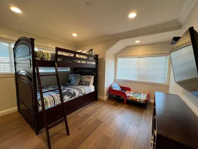 a bedroom with two bunk beds and a desk at Fantastic 6 bedroom, 45 bath home (4 master Suites), pool home in Anaheim