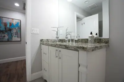 a bathroom with a sink and a mirror at 4 bedroom, 3 bathrooms Pool Home in Orange