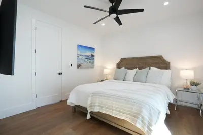 a bedroom with a large bed with a ceiling fan at 4 bedroom, 2 bathrooms in Orange