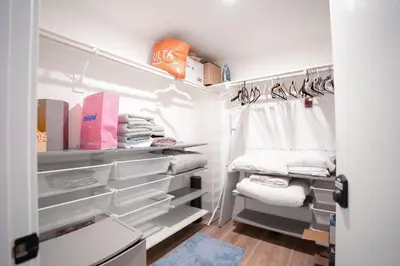 a walk in closet with white shelves and towels at Glam by the Hollywood Sign 2 Bed Apt WITH FREE EV PARKING, Pool, Gym in Los Angeles