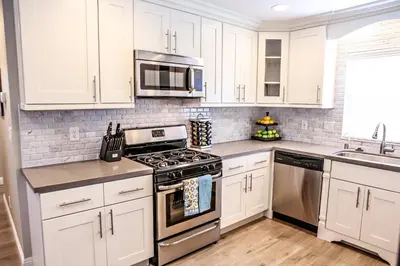 a kitchen with white cabinets and stainless steel appliances at Adorable 3 Bedroom 2 Bath Home in Fullerton