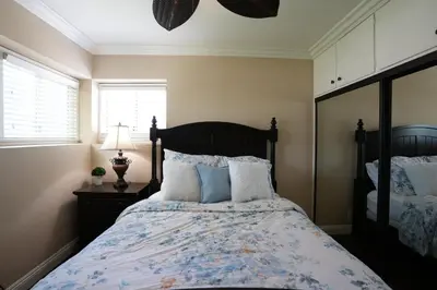 a bedroom with a bed with blue and white pillows at Charming Anaheim Home 1/2 Mile Walk to Disney in Anaheim