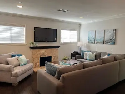 a living room with two couches and a fireplace at Gorgeous Pool Home 1/2 Mile Walk to Disney in Anaheim