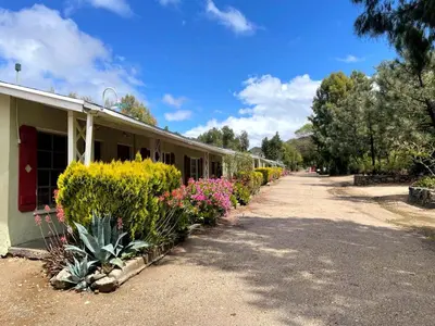 a building with a bunch of plants next to it at Sierra Pelona Motel in Santa Clarita