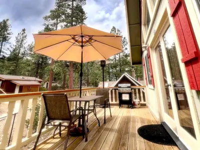 a patio with a table and an umbrella on a deck at 3BR Home w Game Room by The Village, Lake & Summit in Big Bear Lake
