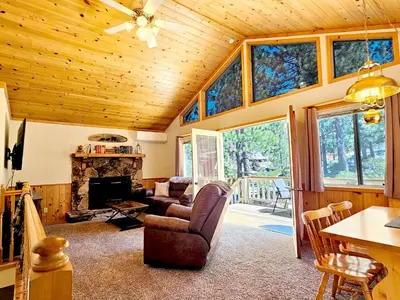 a living room with a fireplace and a wooden ceiling at 3BR Home w Game Room by The Village, Lake & Summit in Big Bear Lake