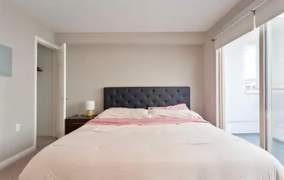 a bedroom with a large bed with a large window at Pacific Blue Townhome Walk to Ocean 2 Bed Apt WITH FREE PARKING in Los Angeles