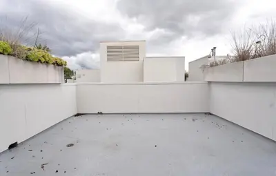 an empty parking lot in front of a white building at Pacific Blue Townhome Walk to Ocean 2 Bed Apt WITH FREE PARKING in Los Angeles