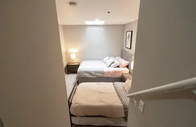 a small room with two beds and a hallway at Pacific Blue Townhome Walk to Ocean 2 Bed Apt WITH FREE PARKING in Los Angeles