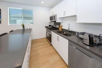 a kitchen with white cabinets and stainless steel appliances at Modern 2BR Back House w/ TVs & Full Kitchen in Los Angeles