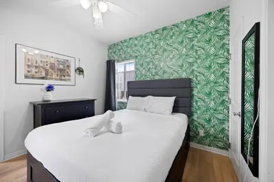 a bedroom with a large bed with a green wall at Cozy Backhouse Stay – Sleeps 2 Beverly Hills Adj in Los Angeles