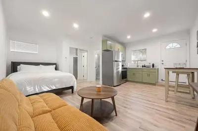 a bedroom with a bed and a kitchen with a table at Lake Balboa Hideaway in Los Angeles