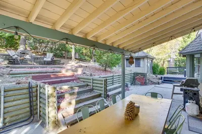 a patio with a grill and a table and chairs at Partial Lake Arrowhead View Cabin with Game Room! in Lake Arrowhead