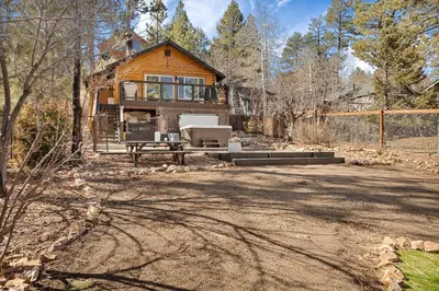 a log house with a driveway in front of it at Serenity Nook in Big Bear with a Hot Tub in Big Bear Lake