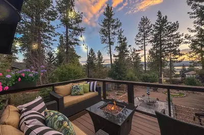 a balcony with a couch and a table with a fire pit at Serenity Nook in Big Bear with a Hot Tub in Big Bear Lake
