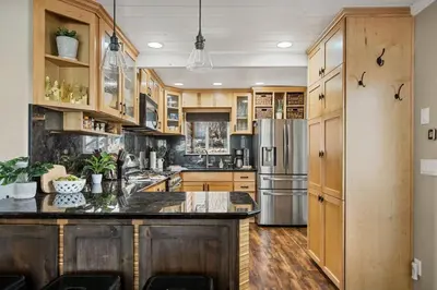 a kitchen with wooden cabinets and a stainless steel refrigerator at Serenity Nook in Big Bear with a Hot Tub in Big Bear Lake