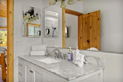 a white bathroom with a sink and a mirror at Llama Bear Lodge with Hot Tub in Big Bear Lake
