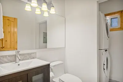 a bathroom with a sink and a toilet and a mirror at Llama Bear Lodge with Hot Tub in Big Bear Lake
