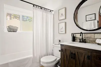 a bathroom with a toilet and a sink and a mirror at Eureka Ranch Designer Cabin in Big Bear Lake