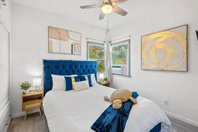 a bedroom with a blue bed with a teddy bear on it at Luxury Beachside Gem Walk to Beach Ocean Views in Manhattan Beach