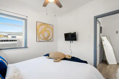 a teddy bear sitting on a bed in a bedroom at Luxury Beachside Gem Walk to Beach Ocean Views in Manhattan Beach