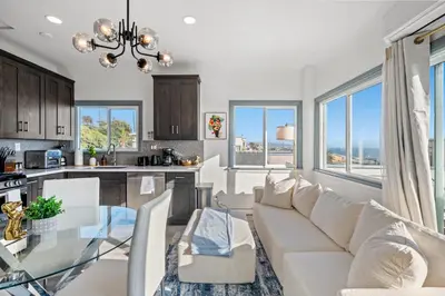 a kitchen and living room with a couch and a table at Luxury Beachside Gem Walk to Beach Ocean Views in Manhattan Beach