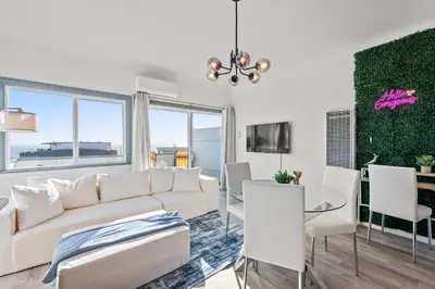 a living room with a white couch and a table and chairs at Luxury Beachside Gem Walk to Beach Ocean Views in Manhattan Beach
