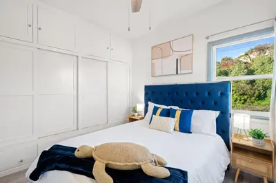 a bedroom with a bed with a teddy bear on it at Luxury Beachside Gem Walk to Beach Ocean Views in Manhattan Beach