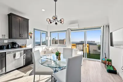 a kitchen and dining room with a glass table at Luxury Beachside Gem Walk to Beach Ocean Views in Manhattan Beach