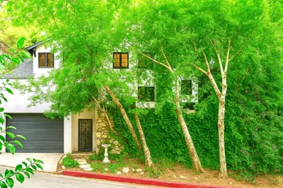 a house covered in green ivy with a garage at Enchanting Hollywood Hills Oasis with Tree-Top Views, Serene Outdoor Living Room, Zen Garden, Free Attached Garage, Sleeps 6, in LA's Most Desirable, Central, Serene Canyon Neighborhood, and Only 2 Minutes to Hollywood Boulevard in Los Angeles
