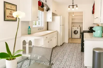 a kitchen with white cabinets and a plant in a chair at Enchanting Hollywood Hills Oasis with Tree-Top Views, Serene Outdoor Living Room, Zen Garden, Free Attached Garage, Sleeps 6, in LA's Most Desirable, Central, Serene Canyon Neighborhood, and Only 2 Minutes to Hollywood Boulevard in Los Angeles