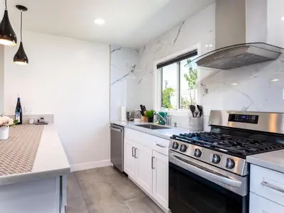 a kitchen with white counters and a stove top oven at Gated & remodeled 2b2b house 3373 in Baldwin Park