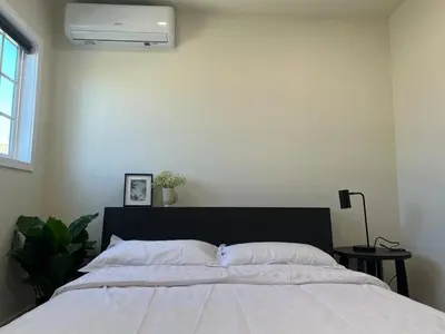 a bedroom with a bed with a white bedspread at Gated & remodeled 2b2b house 3373 in Baldwin Park
