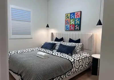 a bedroom with a bed with black and white sheets at #Marbella Lane - Stylish Haven Near City Center in Long Beach