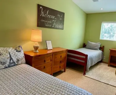 a bedroom with two beds and a dresser and a chalkboard at Cozy Guesthouse with Private Pool and Heated Jacuzzi in Santa Clarita