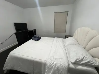 a bedroom with a white bed with a blue bag on it at Near Disney,college,sunset beach ,airport in Norwalk