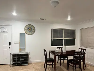 a dining room with a table and a clock on the wall at Near Disney,college,sunset beach ,airport in Norwalk